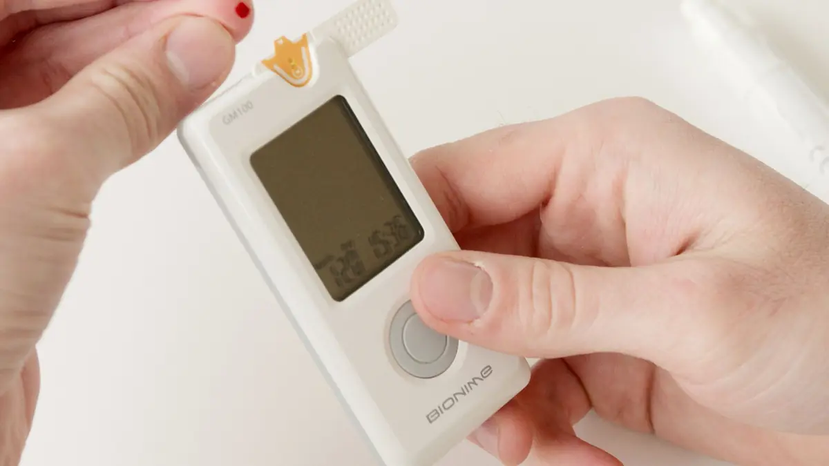 Close-up of hands using a glucose meter